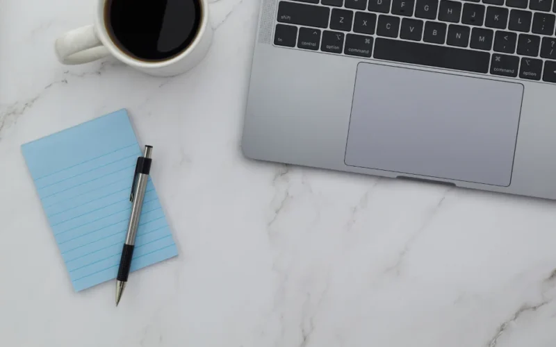 Minimal laptop workspace for designing a brochure