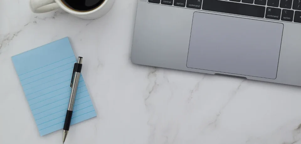 Minimal laptop workspace for designing a brochure