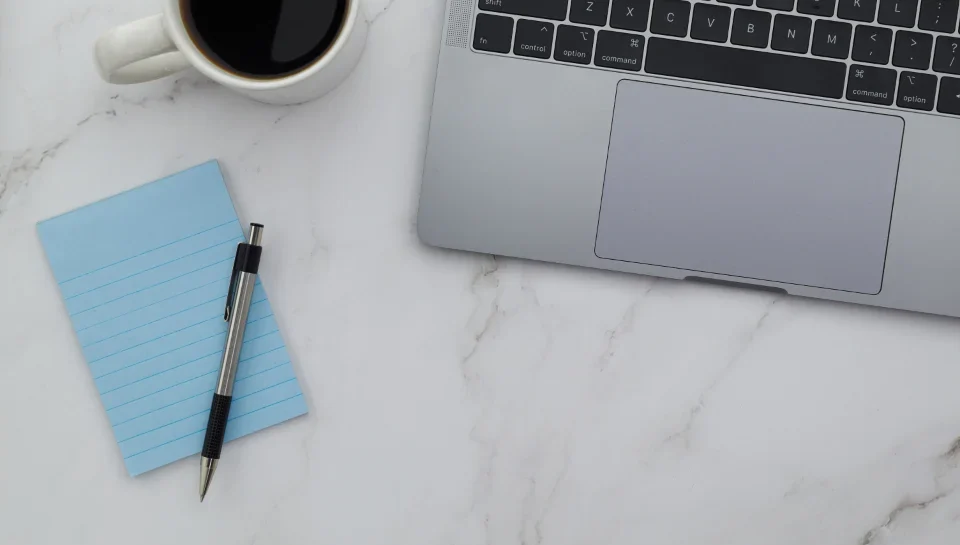 Minimal laptop workspace for designing a brochure