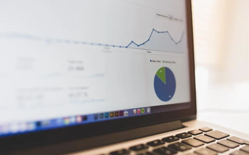 A seller reviewing a buyer engagement dashboard showing brochure views and chats on a laptop