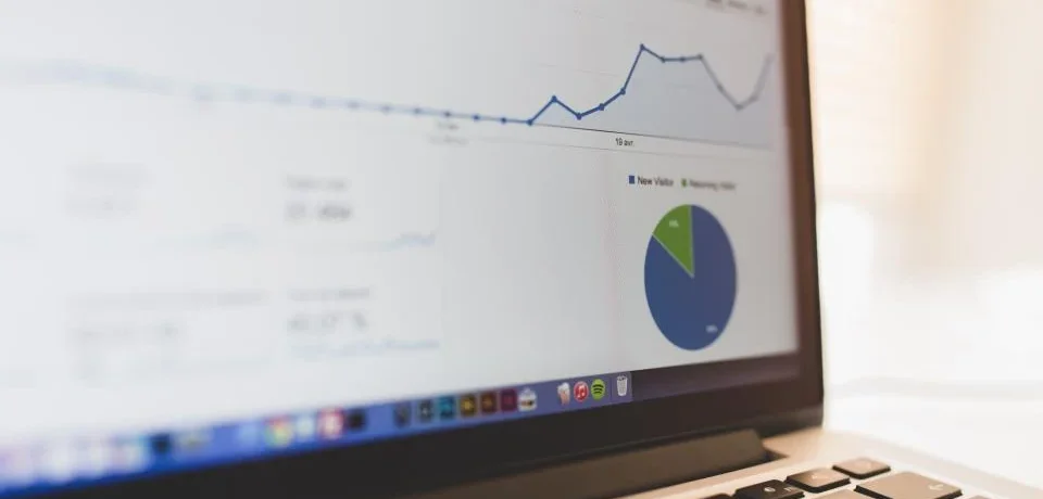 A seller reviewing a buyer engagement dashboard showing brochure views and chats on a laptop