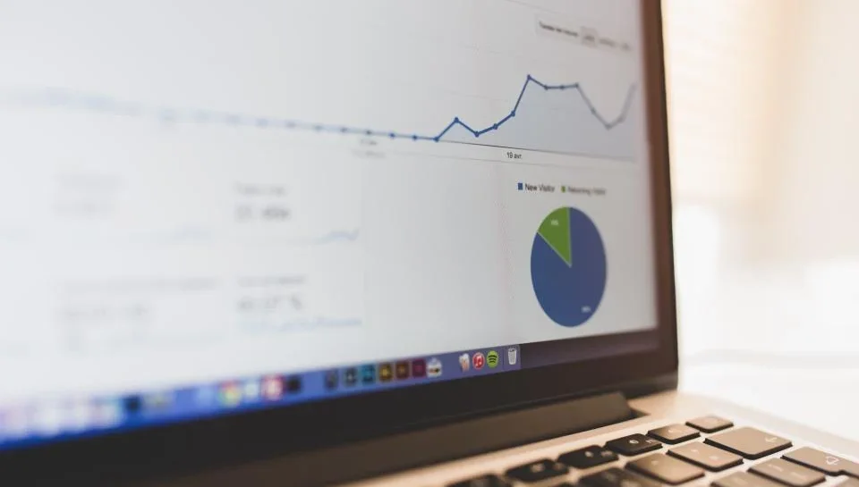 A seller reviewing a buyer engagement dashboard showing brochure views and chats on a laptop