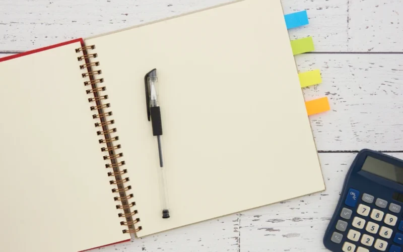 Business owner reviewing profit-and-loss statements and a calculator to value a small business for sale
