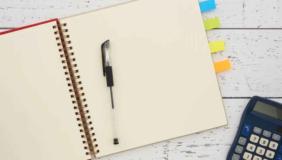 Business owner reviewing profit-and-loss statements and a calculator to value a small business for sale