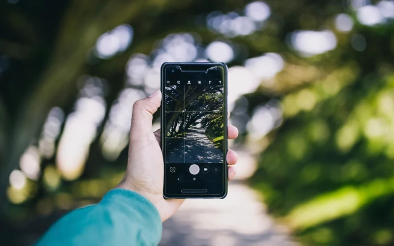 Hand holding a smartphone outdoors