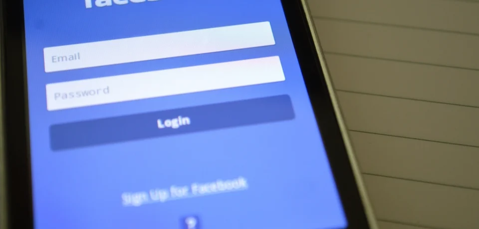 A phone showing a real estate agent's social media feed with listing photos and captions