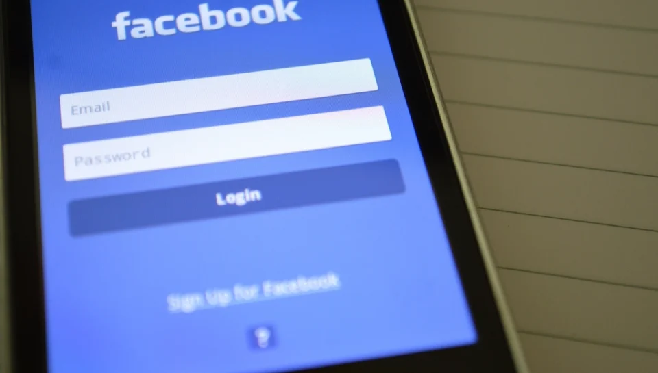 A phone showing a real estate agent's social media feed with listing photos and captions